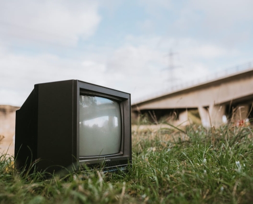 Vintage TV set on grassy seashore